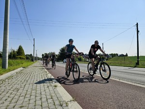 Zdjęcie przedstawia: kobietę i mężczyznę jadących na rowerach.