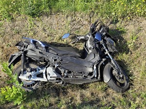 Zdjęcie przedstawia: motocykl leżący na trawie.