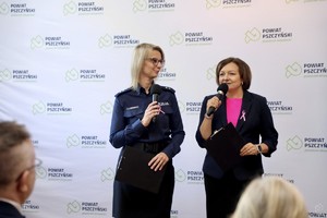 zdjęcie przedstawia: policjantkę wraz z lektorką, która przemawia do mikrofonu.