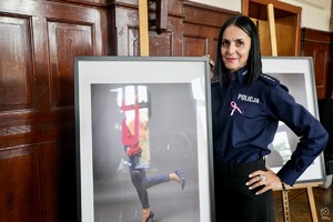 zdjęcie przedstawia: policjantkę wraz ze swoim zdjęciem z wystawy.