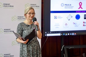 zdjęcie przedstawia: kobietę, która czyta i mówi do mikrofonu.