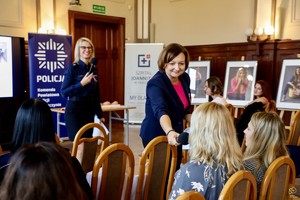 zdjęcie przedstawia: kobietę podającą mikrofon uczestniczce.