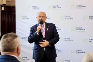 zdjęcie przedstawia: mężczyznę mówiącego do mikrofonu.