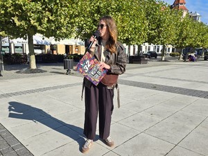 zdjęcie przedstawia: kobietę przemawiającą przez mikrofon.
