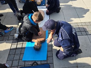 zdjęcie przedstawia: policjanta wraz z uczestnikiem wydarzenia.