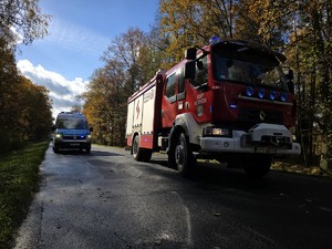 Zdjęcie przedstawia wóz strażacki oraz radiowóz na miejscu zdarzenia.