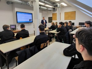 Zdjęcie przedstawia nie umundurowanego policjanta podczas zajęć w szkole.