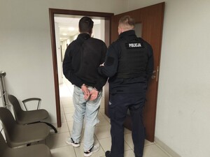 Zdjęcie przedstawia policjanta z osobą zatrzymaną.