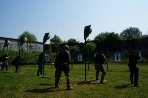 Policjanci w pozycji stojącej strzelają do tarcz