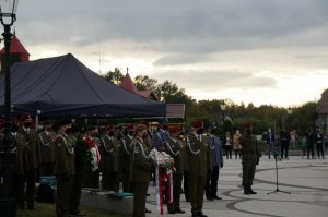 Delegacja wojska składa wiązankę pod tablicą zabitych saperów