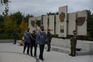 Delegacja służb mundurowych wraca po złożeniu wiązanki pod pamiątkową tablicą