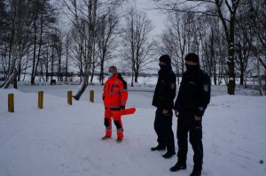 Policjanci z ratownikiem wodnym kontrolują stawy pod kątem przebywania dzieci na lodzie