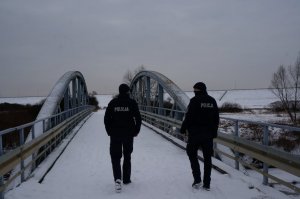 Dzielnicowi idą mostem na Płoni sprawdzają czy nikt nie przebywa na lodzie