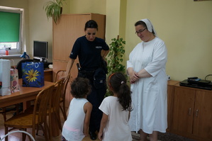 Policjantka i zakonnica oraz dzieci stoją obok siebie
