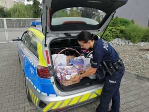 Policjantka wkłada słodycze do radiowozu