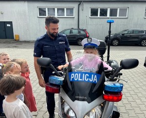 na zdjęciu dziewczynka na policyjnym motocyklu