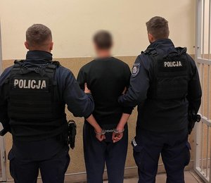 na zdjęciu zatrzymany kierujący z policjantami stoją tyłem