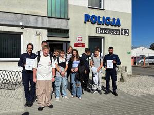 na zdjęciu uczniowie i policjanci przed komendą