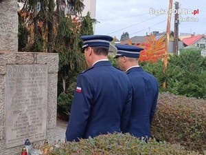 na zdjęciu policjanci stoją przy pomniku w mundurze galowym