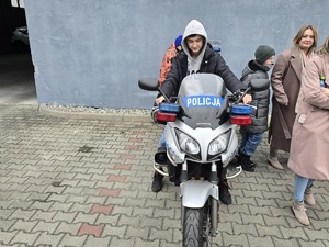 na zdjęciu chłopiec na motocyklu policyjnym