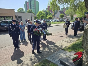 na zdjeciu przedstawiciele służb pod obeliskiem składaja kwiaty