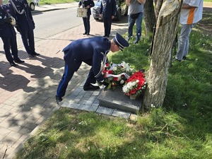 na zdjeciu przedstawiciele służb pod obeliskiem komendant składa kwiaty
