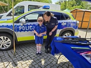 na zdjeciu policjantka z dziewczynka w stoju policjanta