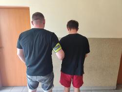 na zdjęciu zatrzymany z policjantem tyłem