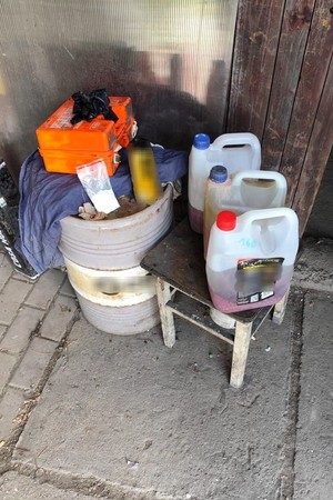 Zdjęcie kolorowe przedstawiające środki odurzające oraz sprzęt do produkcji narkotyków.