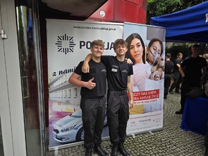 na zdjęciu uczniowie klasy mundurowej stoją przy banerze