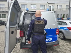 na zdjęciu policjant zamykający radiowóz
