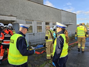 na zdjęciu widać jak policjant pomaga osobom poszkodowanym w wypadku