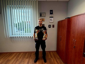 na zdjęciu policjant z pucharami