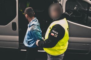 zdjęcie - policjant i zatrzymany 29-latek przy nieoznakowanym policyjnym radiowozie
