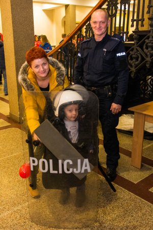 zdjęcie przedstawia policjanta, chłopca i jego mamę pozujących do zdjęcia