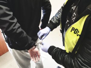 zdjęcie - policjant z zatrzymanym, ściąga kajdanki