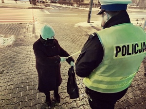zdjęcie z akcji świeć przykładem - noś odblask - policjant przekazał odblaskową opaskę starszej kobiecie