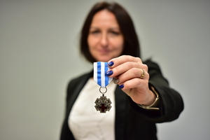 zdjęcie przedstawia kobietę z odznaką honorowego dawcy krwi