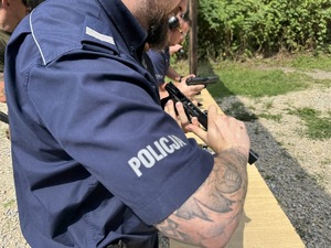 zdjęcie z treningu strzeleckiego pokazuje policjantów ćwiczących rozkładanie broni służbowej