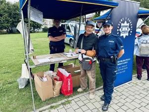 Senior pozuje do zdjęcia z policjantami