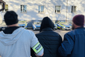 zdjęcie przedstawia policjantów prowadzących zatrzymanego