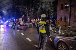 zdjęcie przedstawia policjantkę z drogówki zabezpieczającą drogę podczas przemarszu