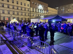 zdjęcie z koncertu policyjnej orkiestry na rudzkim jarmarku - policyjni muzycy grający i mieszkańcy słuchający ich