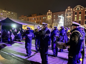 zdjęcie z koncertu policyjnej orkiestry na rudzkim jarmarku - policyjni muzycy grający przed zebranymi na jarmarku