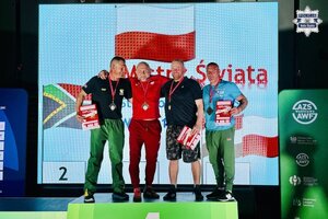 Zawodnicy zawodów na podium pozują do zdjęcia