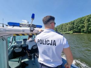 Policjant na łodzi monitoruje linię brzegową nad Zalewem Rybnickim.