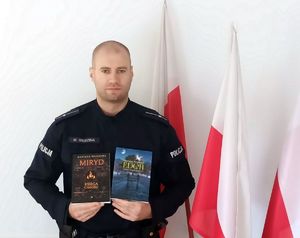 Policjant prezentuje swoje książki.