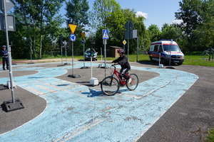 Na zdjęciu uczeń na rowerze zdający test na miasteczku ruchu drogowego.