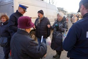 Na zdjęciu policjanci rozdają seniorom odblaski.