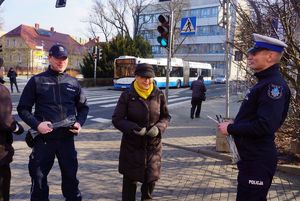 Na zdjęciu policjanci wraz z seniorką, która otrzymała opaskę odblaskową.